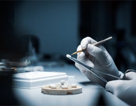 A lab worker processing dental crowns in Cumming