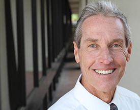 An older man with a denture in Cumming smiling.