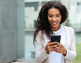 person smiling and looking at their phone