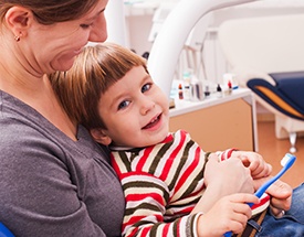 Child in mother's lap at dentist