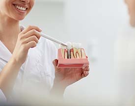 dentist showing a patient how dental implants work