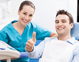 Man in dental chair giving thumbs up