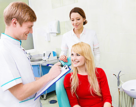 Woman in dental chair smiling at dentist