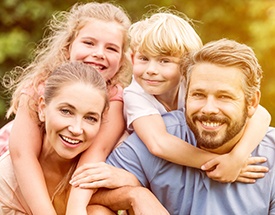 Smiling family of four outdoors