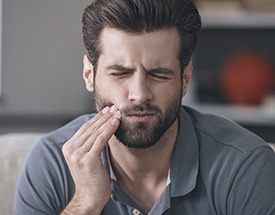 Man holding his cheek in pain