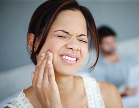 Woman holding cheek in pain