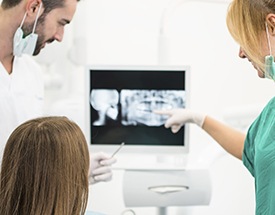 Dentist and patient looking digital x-rays