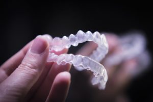 woman hand holding Invisalign aligners